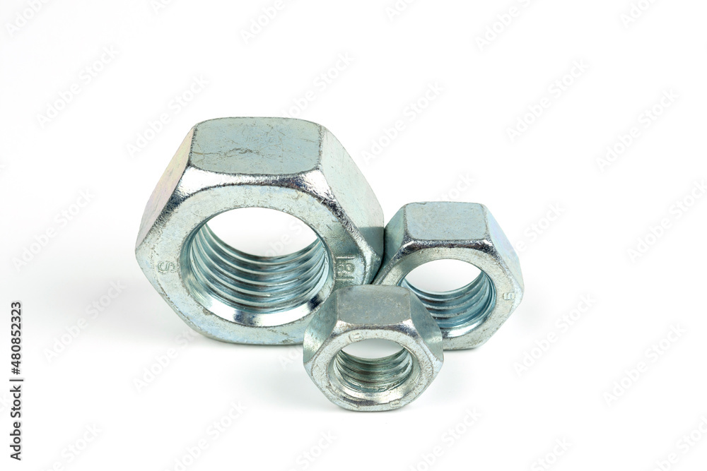 several large nuts made of silver metal on a white background. close-up several large nuts made of silver metal on a white background. close-up