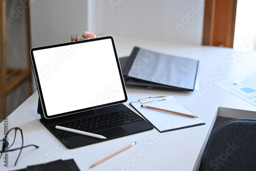 Mockup computer tablet with empty display on white office desk.