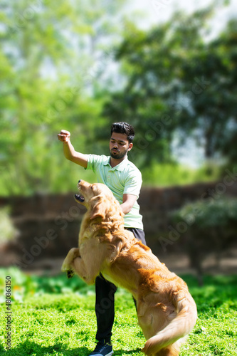 young man playing fetch with his golden retriever