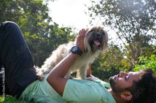 Photography young man playing fetch with his Dog in the park
