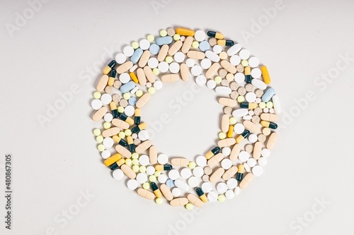 Lots of colorful medicines and pills. Pharmaceutical pattern in the form of a circle. Place for text. Composition on a light background.