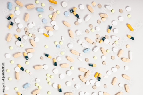 Pharmaceutical pattern of many multicolored drugs and pills. Composition on a light background. Healthy care concept.