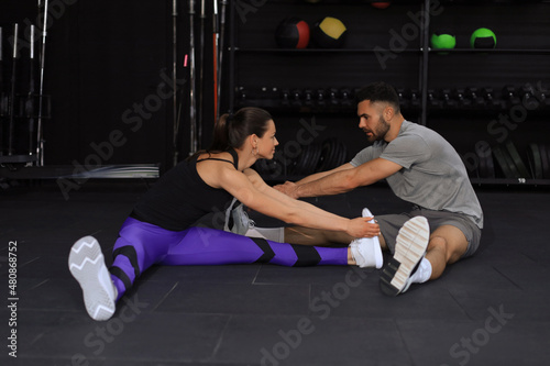 Portrait of a muscular couple doing leg stretchings