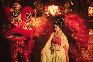 woman in Chinese traditional dress with Chinese lion dancing in for Chinese new year