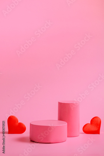 Valentine's day background with podiums for products or cosmetics with hearts on a pink background. closeup. Vertical Format