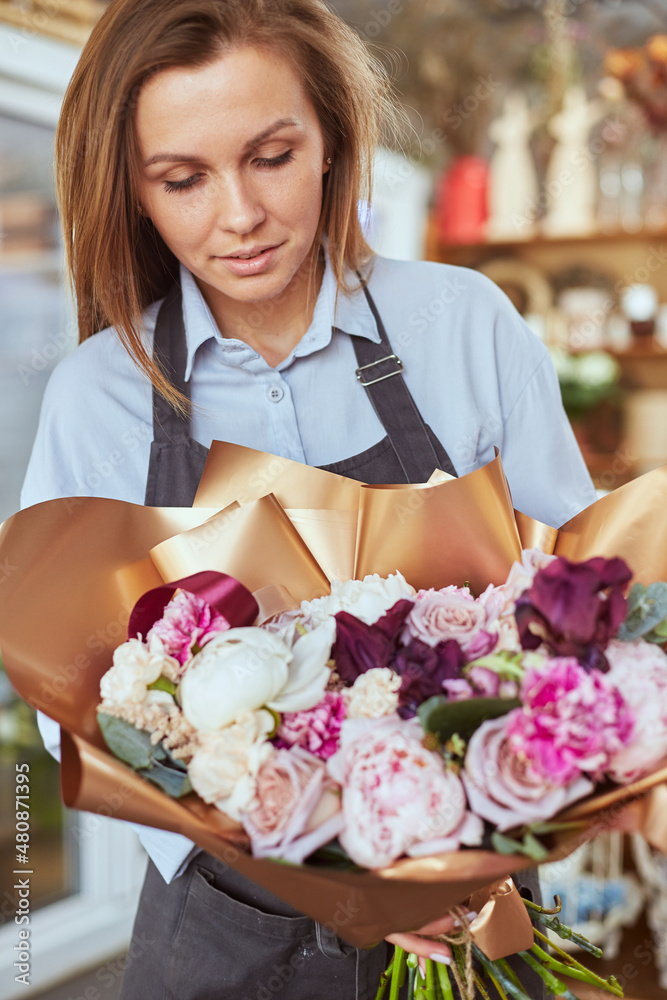 Florist with freshly made bouquet at flower shop Florist with freshly made bouquet at flower shop