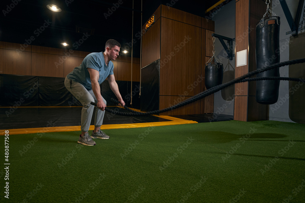 Obraz premium Focused young sportsperson training in fitness room