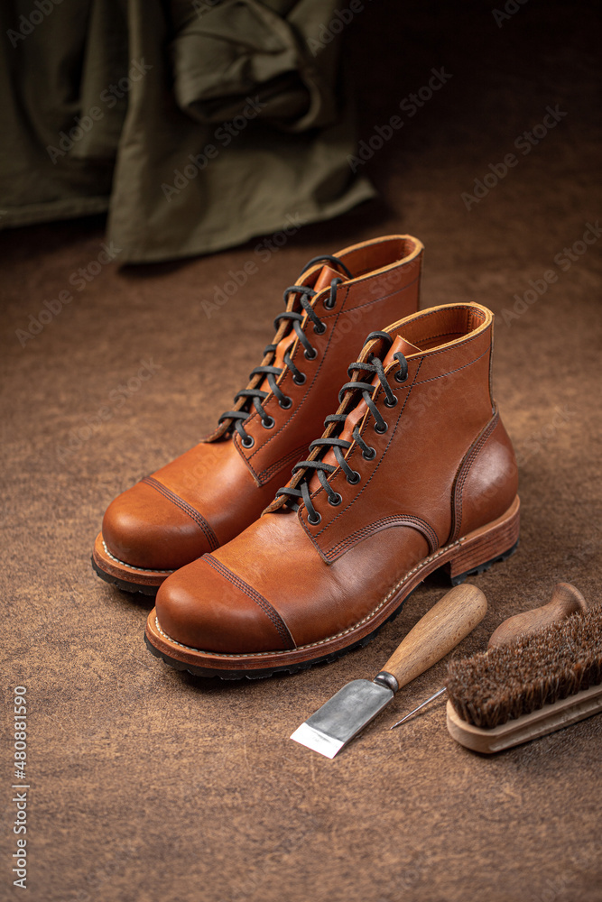 Handcrafted brown leather shoes with cobbler tools on the backgound Handcrafted brown leather shoes with cobbler tools on the backgound