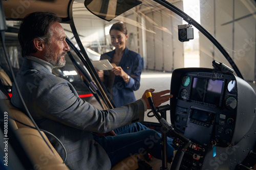 Mature Caucasian man sitting in helicopter cockpit