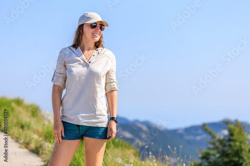 Young smiling woman enjoying hiking trip to the mountains.