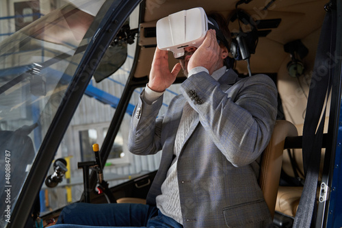 Man playing a 3D simulation game in hangared chopper photo