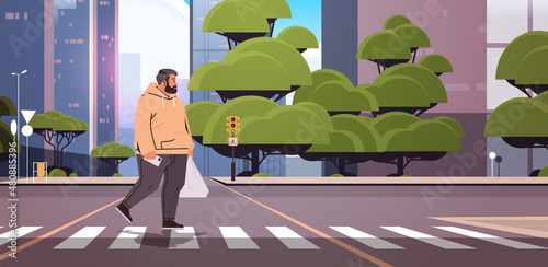 overweight man with shopping plastic bag walking on street pedestrian crosswalk cityscape background