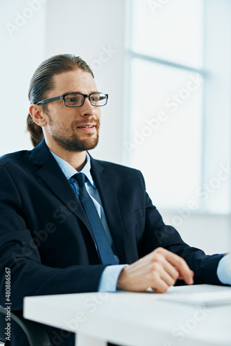 business man with glasses in a suit works at the computer in the office