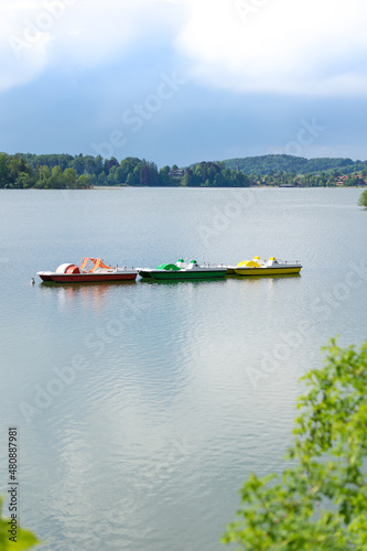 Drei farbige Tretbote auf einem stillen See