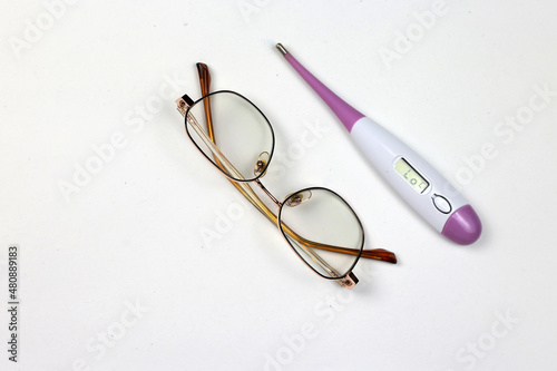 Glasses and digital thermometer on the table