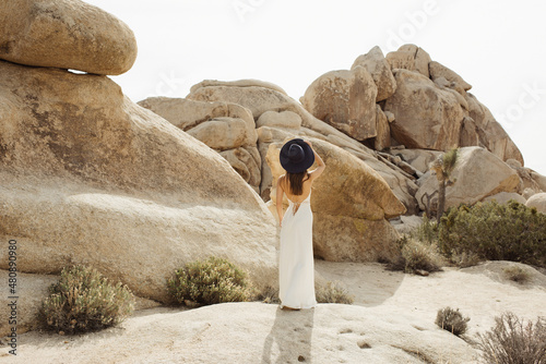 Woman in boho style looking at the rising sun in the Joshua Tree desert