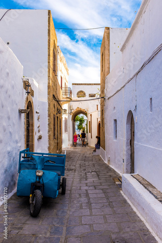 Blue motorized tricycle in whitewashed alley photo