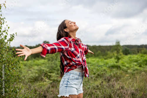 Happy woman standing with arms outstretched at Cannock Chase photo