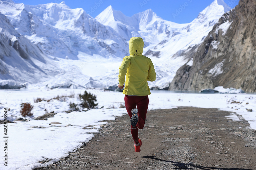 Woman trail runner cross country running in winter nature