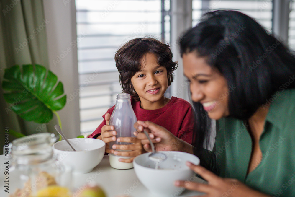 Little boy having breakfast with his mother at home. Little boy having breakfast with his mother at home.