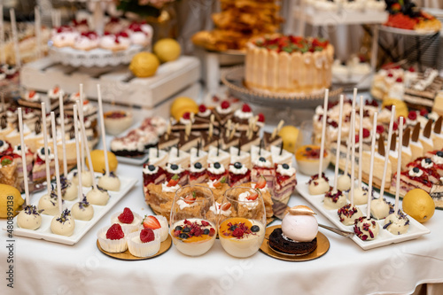 Varied sweet wedding buffet. Festive event. Organization of banquets and weddings. Wedding floristry .Sweet cakes at. wedding banquet. Exquisite wedding desserts.