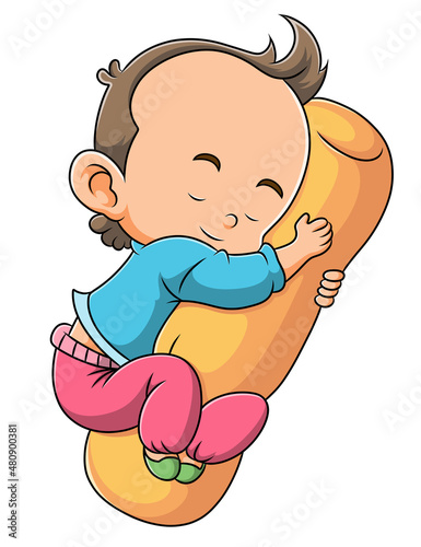 The little boy is sleeping and hugging the bolster