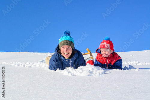 Mutter und Sohn genießen den frischen Pulverschnee an einem sonnigen Wintertag