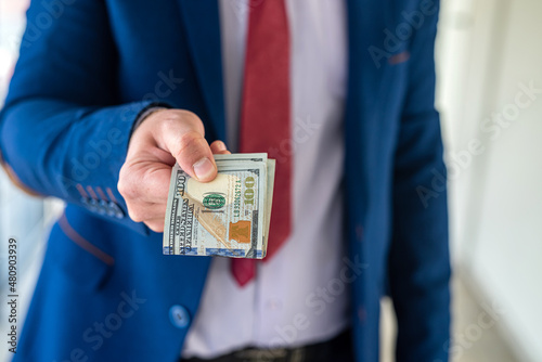 business man holding money US dollar bills for shopping or after success deal