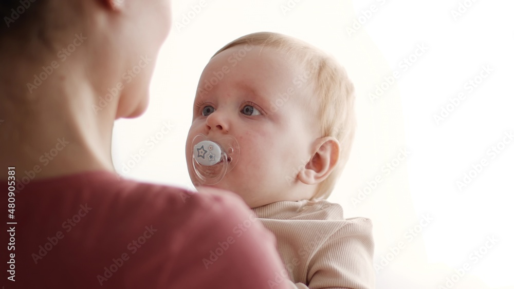 Closeup Shot Of Loving Mom Holding Adorable Infant Baby In Arms Closeup Shot Of Loving Mom Holding Adorable Infant Baby In Arms