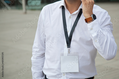 Business man holding empty ID card outdoors