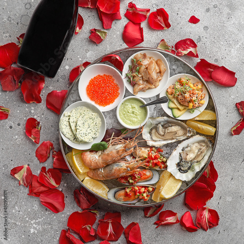 Metal tray with open oysters, raw mussels and caviar. Seafood assortment. On a stone background. Free space for text.