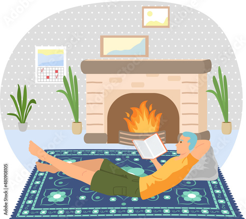 Cute man reading literature. Book lover concept with young man lying relax on floor near fireplace and reading magazine. Concept of homeward and comfort. Person relaxes after work in his apartment