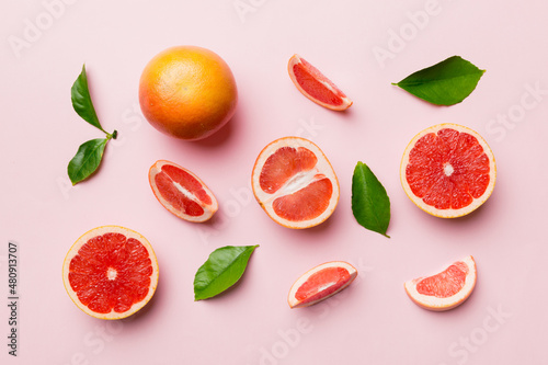 Fototapeta Naklejka Na Ścianę i Meble -  fresh Fruit grapefruit with Juicy grapefruit slices on colored background. Top view. Copy Space. creative summer concept. Half of citrus in minimal flat lay with copy space