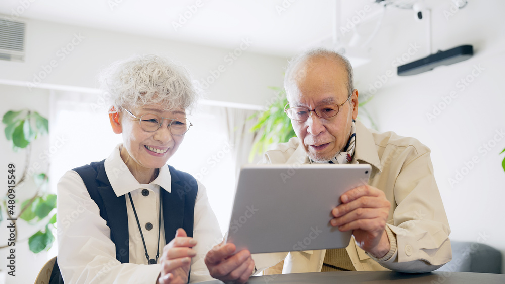 タブレットPCを見るシニア夫婦 タブレットPCを見るシニア夫婦