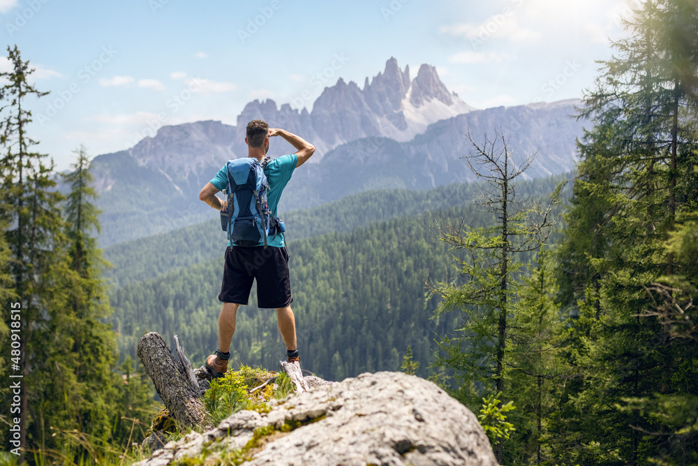 Hiker looking at a beautiful mountain panorama in the Dolomite Alps Hiker looking at a beautiful mountain panorama in the Dolomite Alps