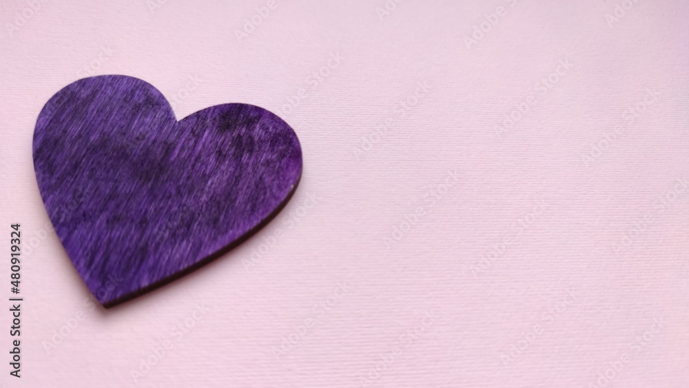 Obraz premium Hand holds a purple heart. Expression of understanding and compassionate love. Love and caring. The concept of parents and children. Military medal for wounded soldiers.