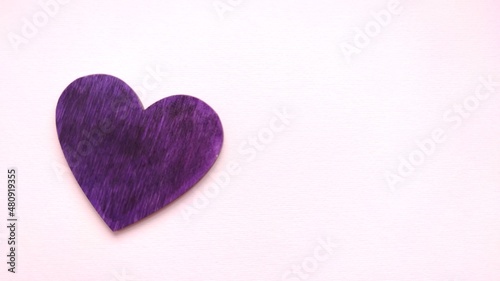 Hand holds a purple heart. Expression of understanding and compassionate love. Love and caring. The concept of parents and children. Military medal for wounded soldiers.