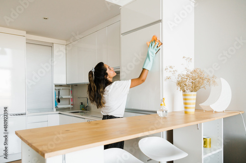 young woman cleaning her apartment photo