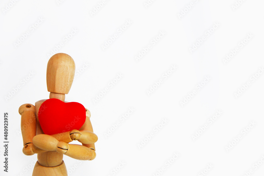 yellow wooden mannequin holding a red heart yellow wooden mannequin holding a red heart