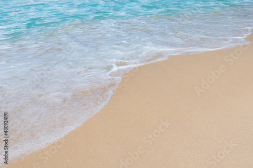 Soft ocean wave on clean sandy beach background