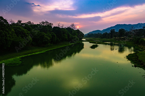 sunrise dramatic sky at dawn with leading river water flow and forest trails © explorewithinfo
