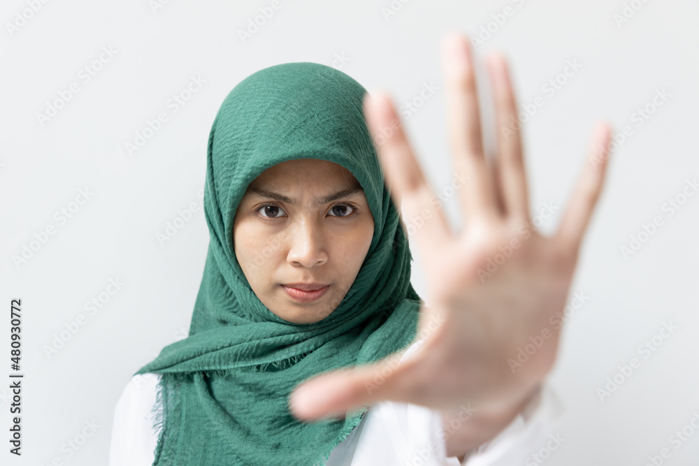 Modern Muslim woman with stop hand gesture, stop asian hate or stop muslim hate or inclusivity and diversity  concept