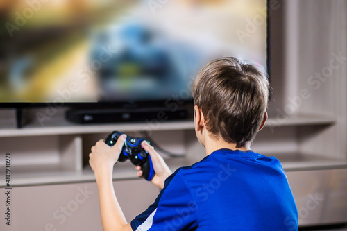 Young gamer playing online video games while streaming on social media. Blurred background and gamepad