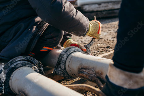 Workers stack iron pipes for pouring concrete before building a bridge