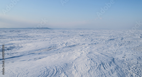 Winter landscape - frozen sea surface with snow.