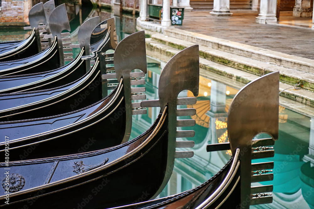 Detail on the steel bow of Venetian gondolas moored in Venice, Italy.