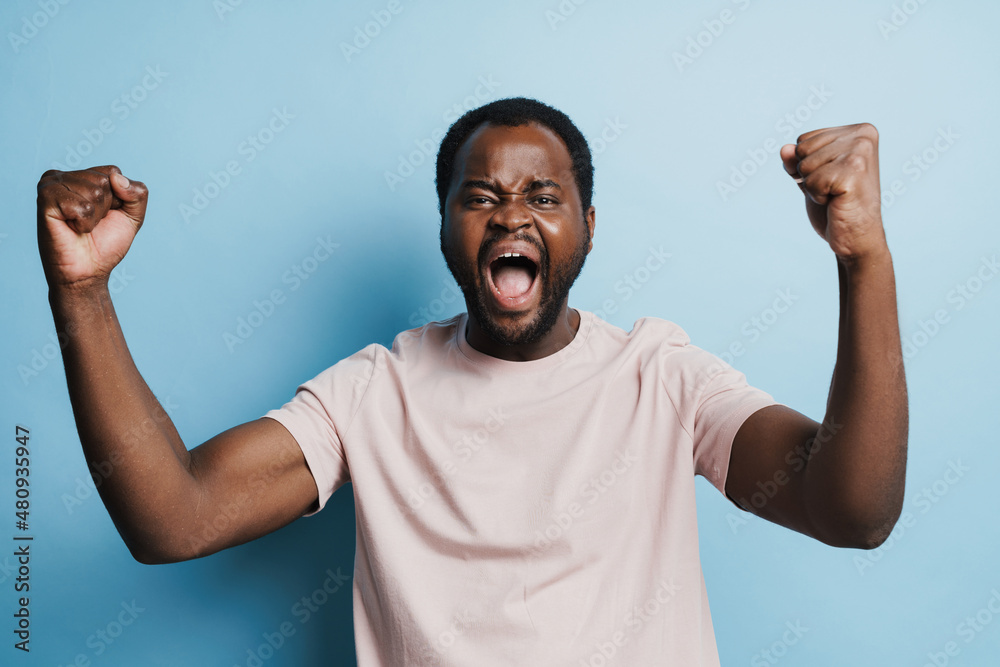 Black bristle man screaming while making winner gesture Black bristle man screaming while making winner gesture
