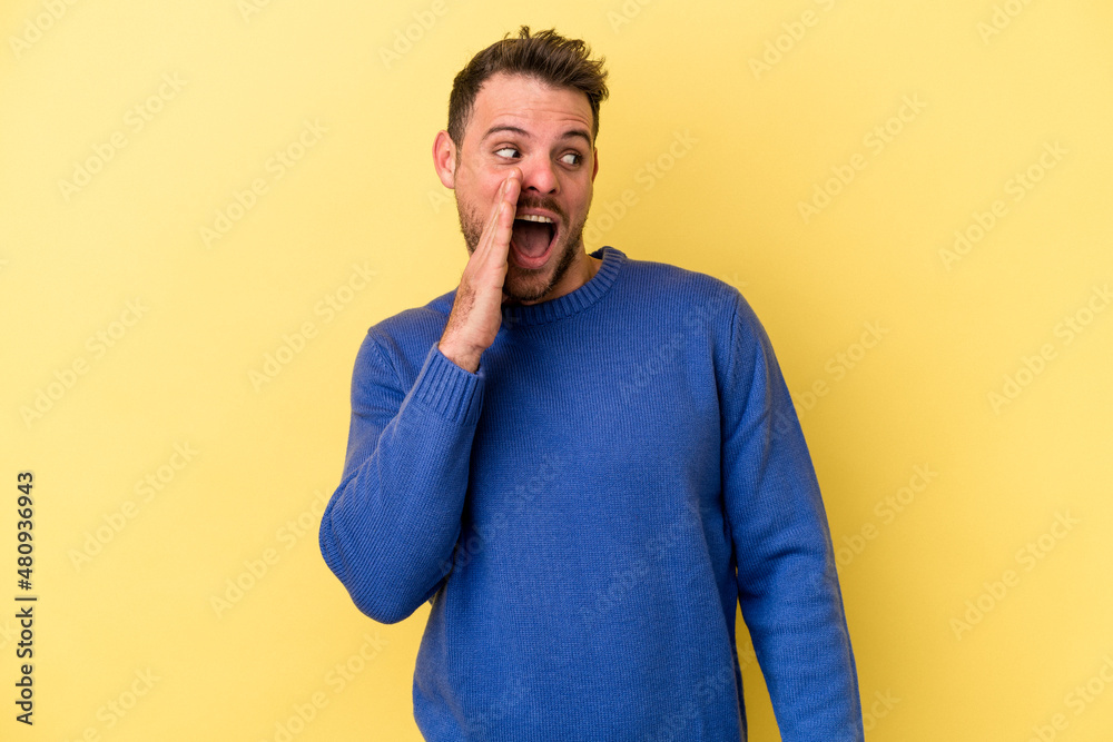 Young caucasian man isolated on yellow background shouting excited to front. Young caucasian man isolated on yellow background shouting excited to front.