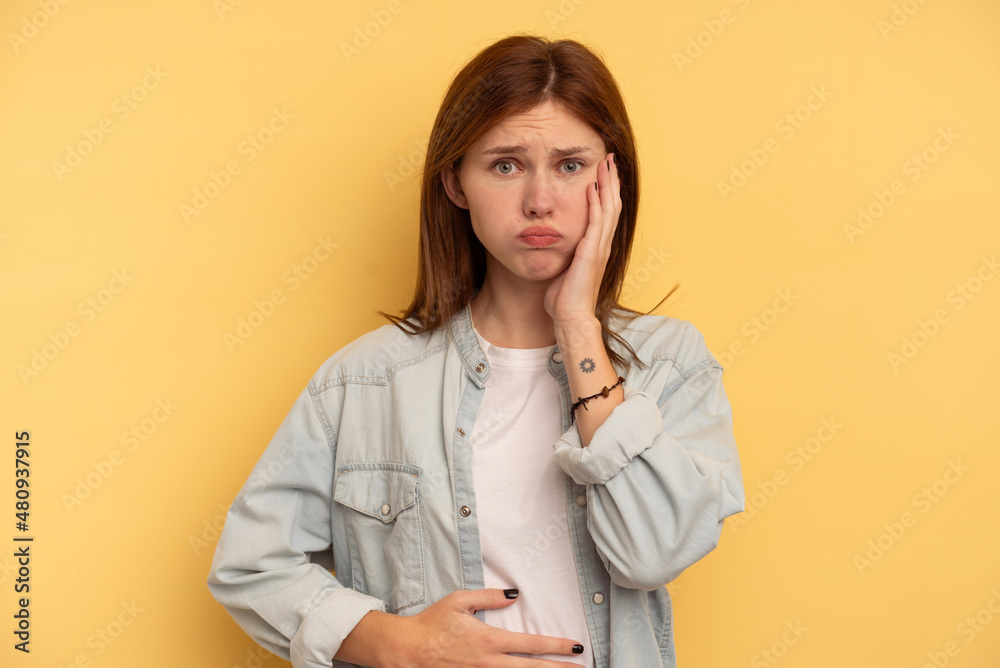 Young English woman isolated on yellow background blows cheeks, has tired expression. Facial expression concept. Young English woman isolated on yellow background blows cheeks, has tired expression. Facial expression concept.