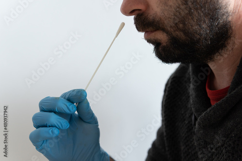 Brown Caucasian man performing an antigen test